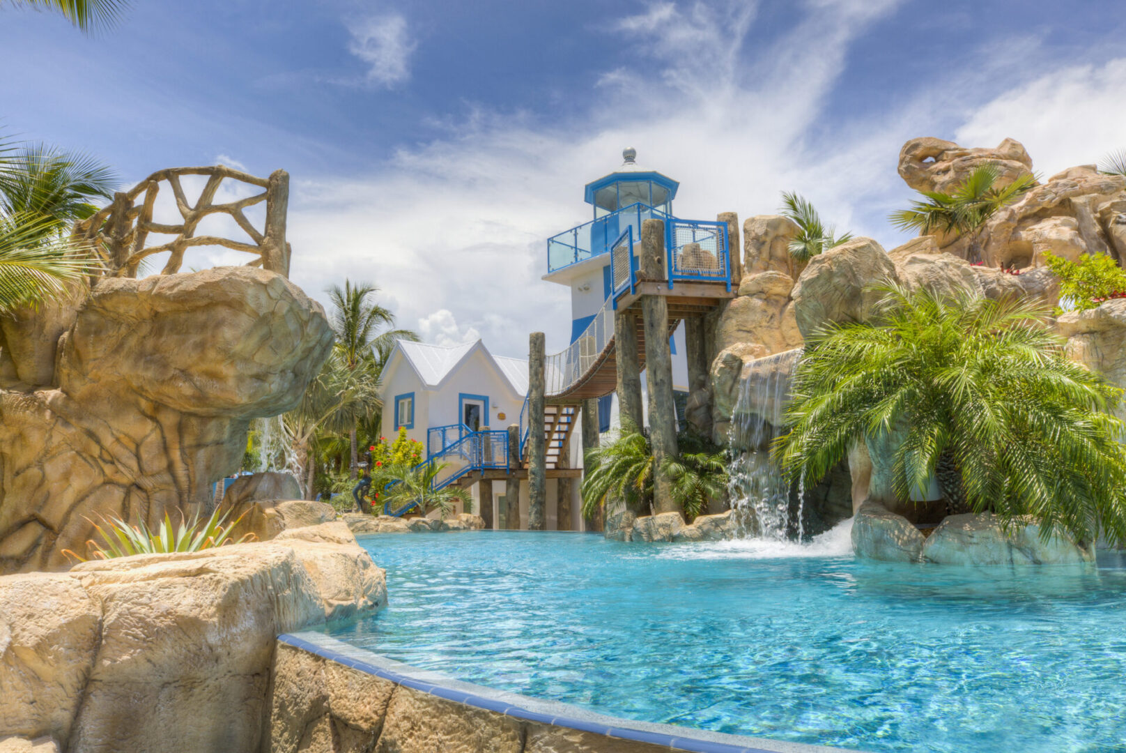 A pool with water slides and a tower.