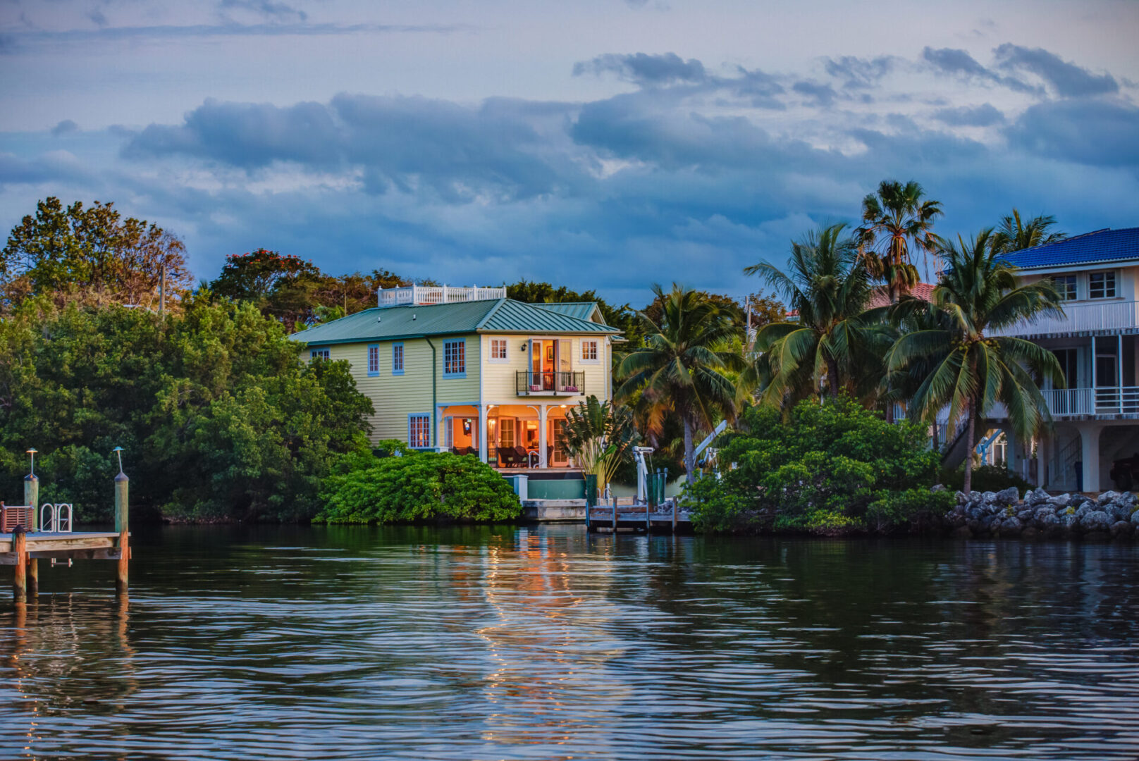 A house on the water with trees in front of it.